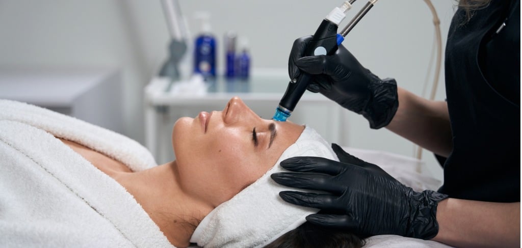 beautician doing facial skin rejuvenation for pretty female