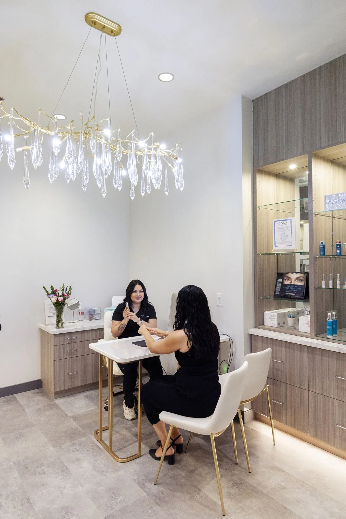 A cosmetic consultant meeting with a client at a table in the Fresno skin care room