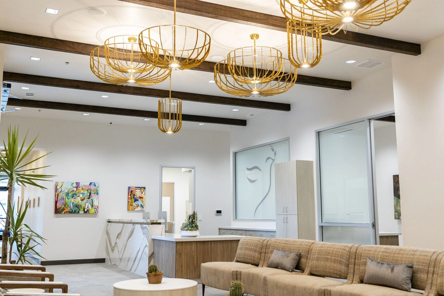 The Visalia lobby and reception desk, with gold chandeliers, wood beams and local art