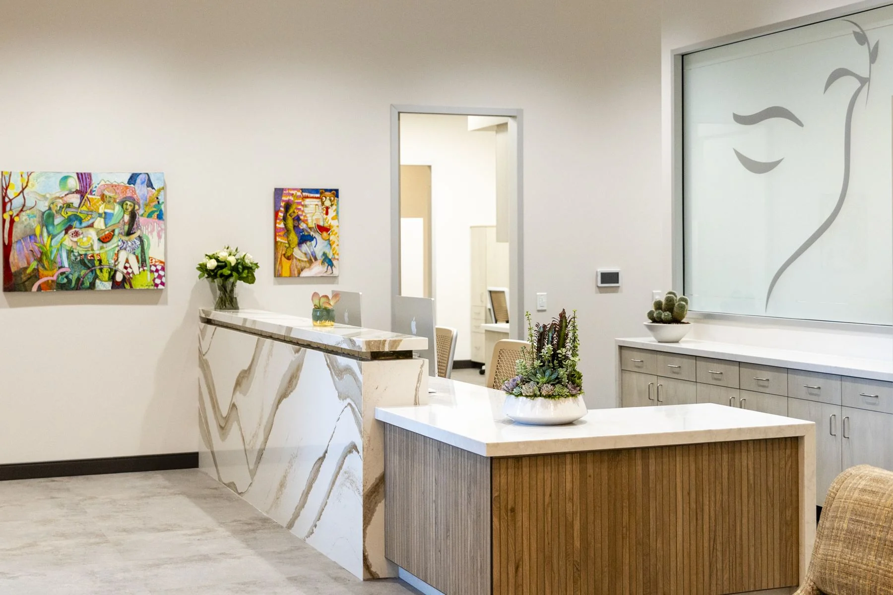 The Visalia reception desk with art and the etched dove